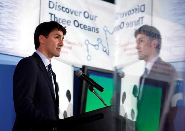 Justin Trudeau s'exprimant à un podium avec une bannière indiquant Découvrez nos trois océans en arrière-plan